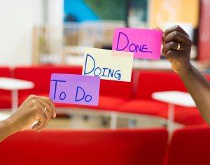 las manos de dos Scrum Master differentes sosteniendo post-its