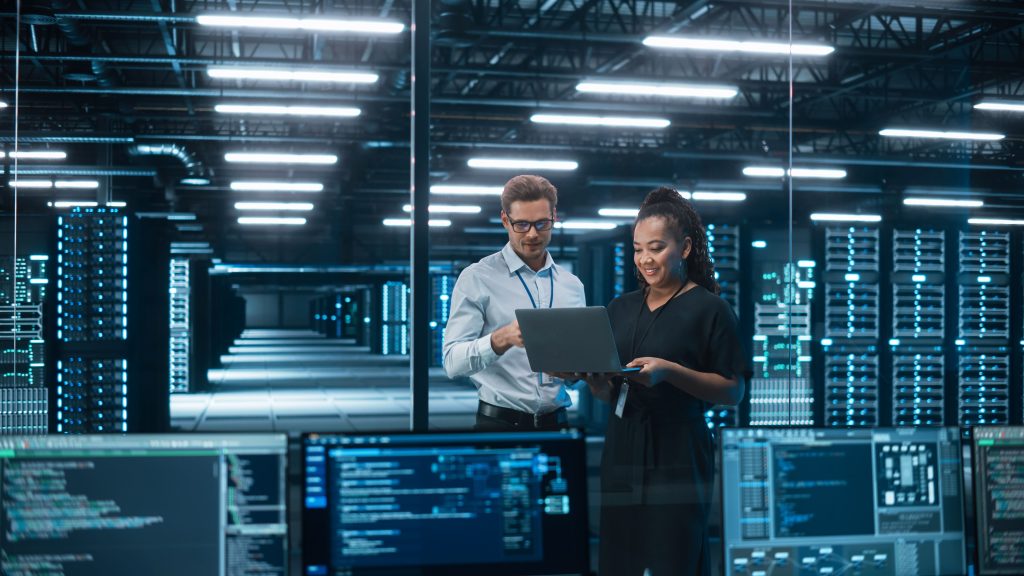 el cio con otra persona en un gran espacio informático observando un portátil